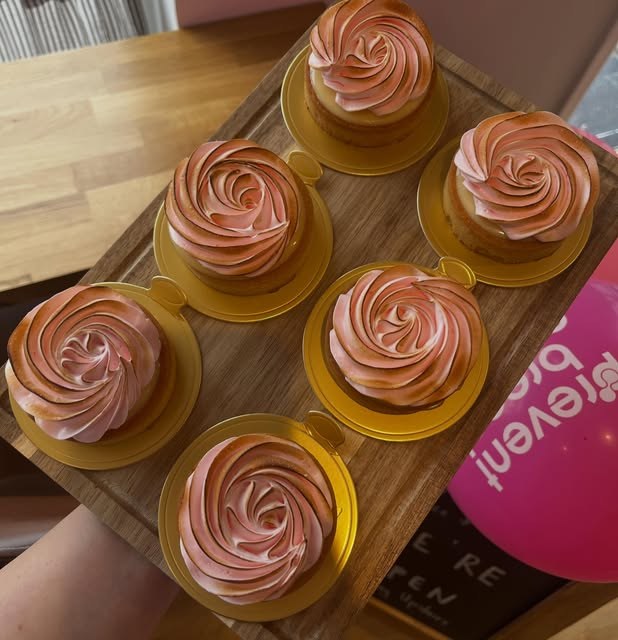 Cupcakes topped with piped rose swirls of pink buttercream