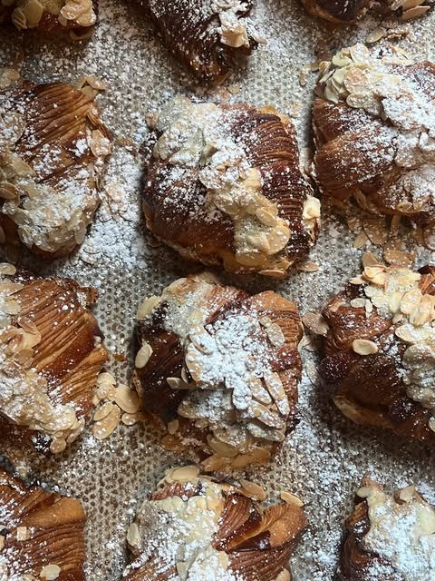Almond croissants dusted with icing sugar and flaked almonds
