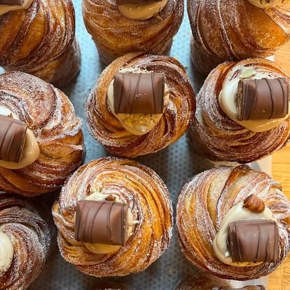 Kinder-topped cruffins dusted with icing sugar on a tray at Lara Patisserie