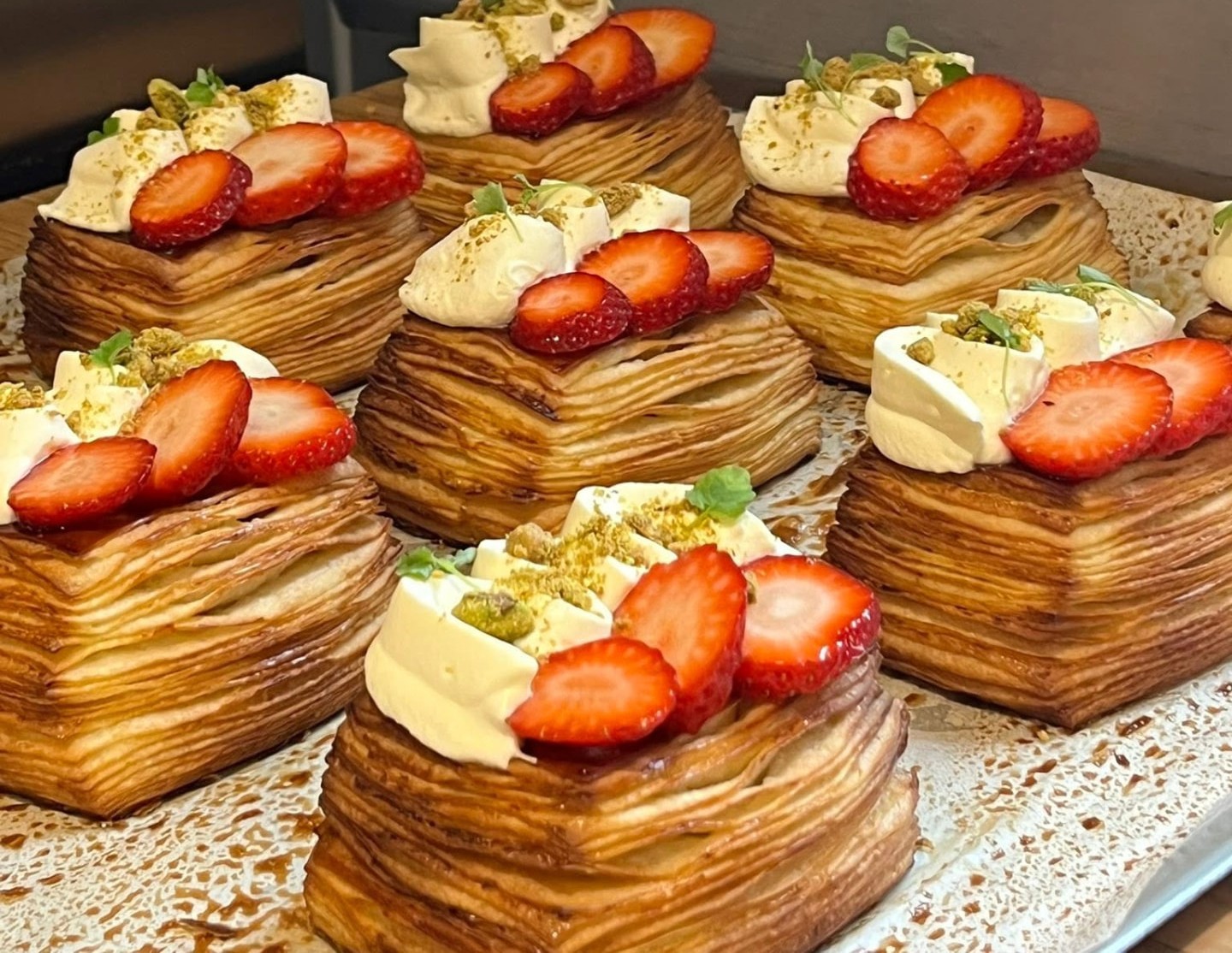 A tray of strawberry and cream mille-feuille pastries with pistachio crumb, fresh from the oven at Lara Patisserie